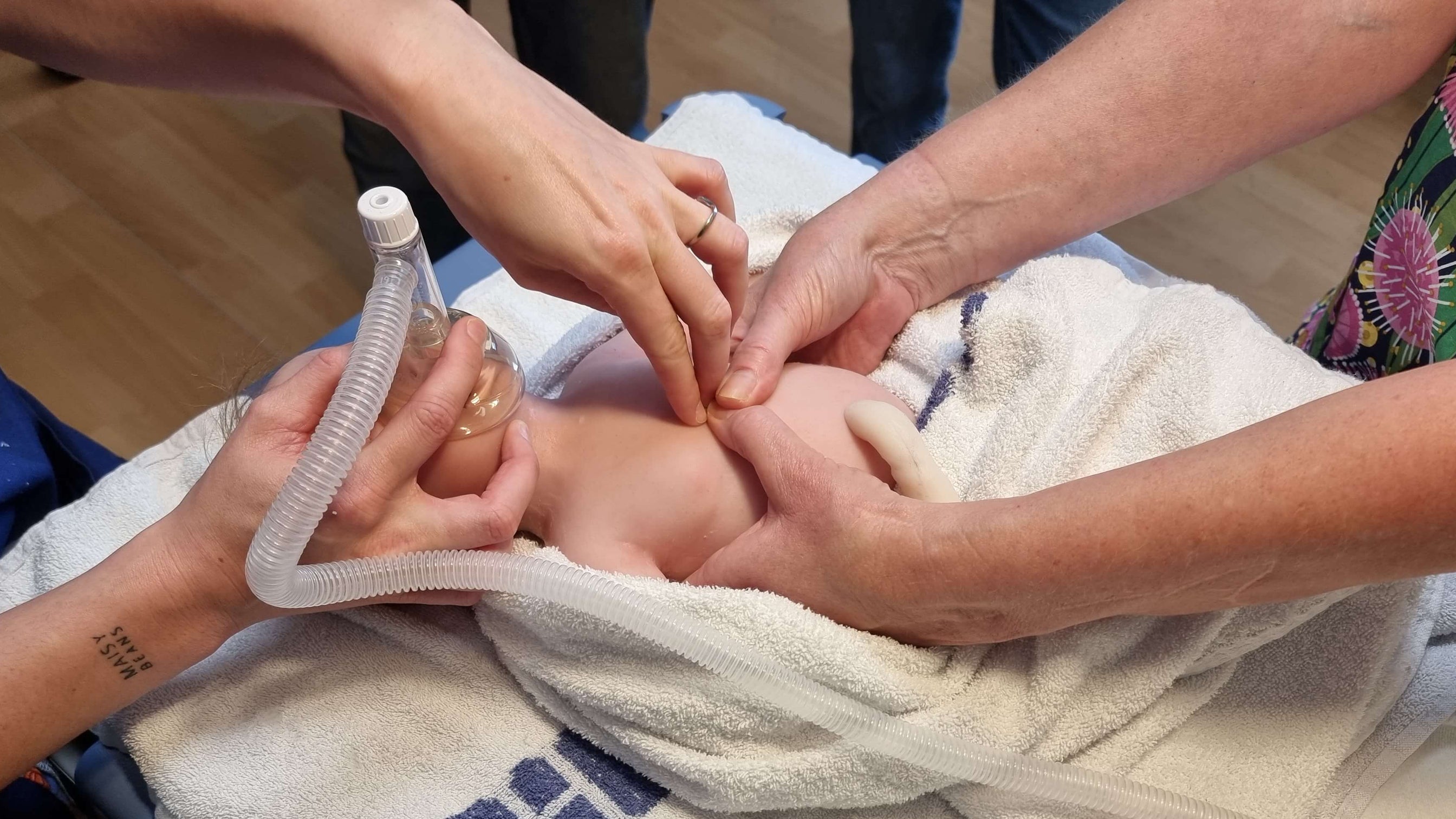 Person giving first aid to a neonate on a towel